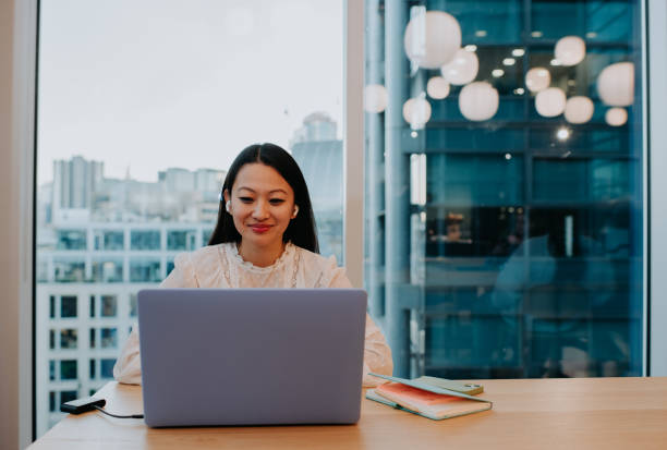 How to stay true to yourself while growing online. Photo of a person in a skyscraper sat at a desk on a laptop.
