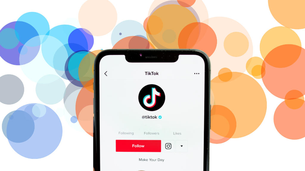TikTok loaded on a smartphone sat against a background of various coloured circles.