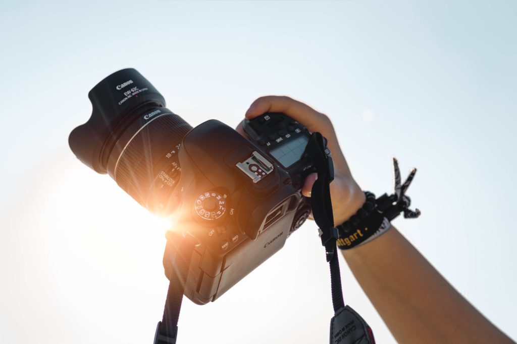 Photography terminology for beginners. Photograph of someone holding a camera up against the sun.