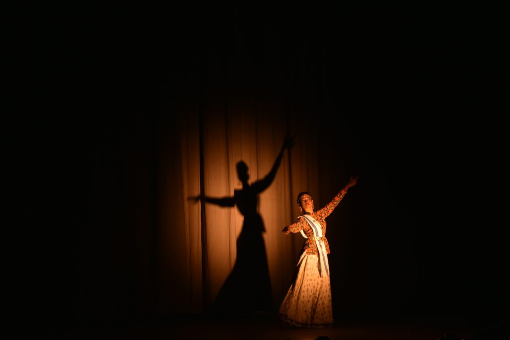 Tips and tricks - preparing for an audition. Photo of a girl with her silhouette performing on a stage.