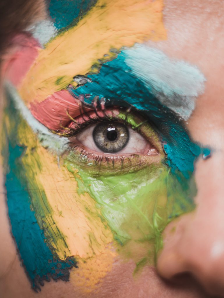 Choosing a creative career path. Photo of up close on someone's eye surrounded by different colours of paint.