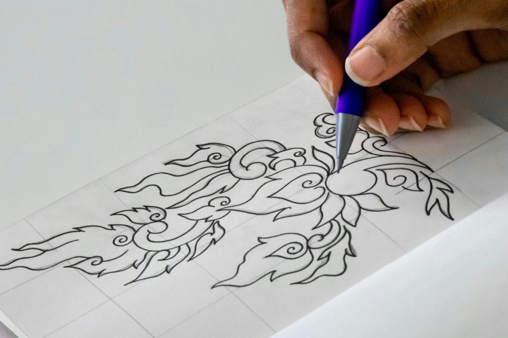 Mastering the art of fine line drawing - essential tips for beginners. Photo of a hand drawing fine line designs.