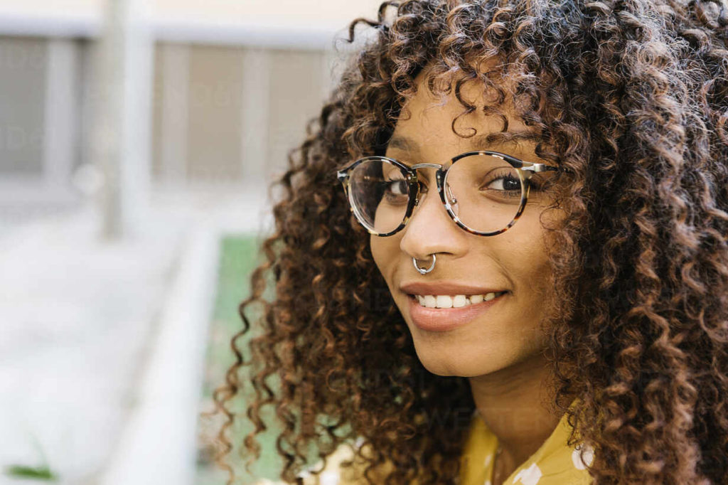 How to successfully use alt text within your images. Close-up headshot of a smiling woman with curly brown hair and glasses.