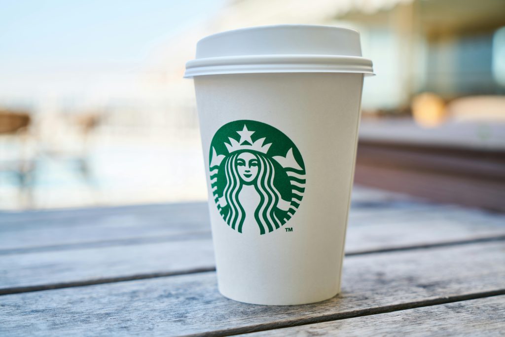 What exactly is a franchise - how do they work, and how can you secure one? Photo of a Starbucks coffee cup.