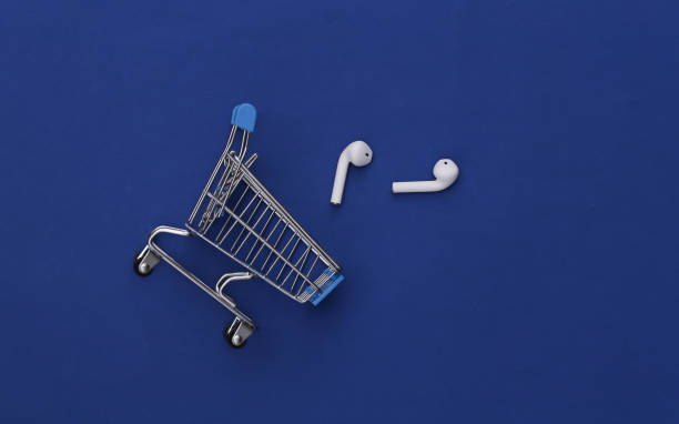 Music retailers - a guide to those who connect artists with fans. Blue background. Foreground has a shopping trolley on its side with ear pods falling out.