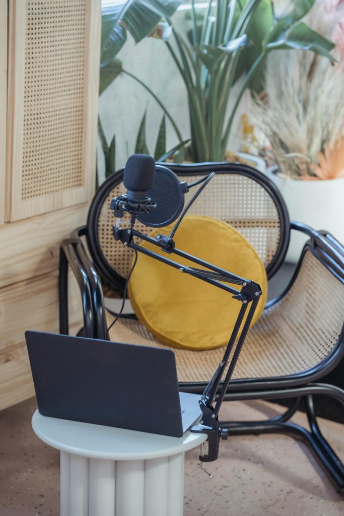 The role of a voice actor and how to become one. Photo of a chair sat in front of a table with a laptop and microphone on.