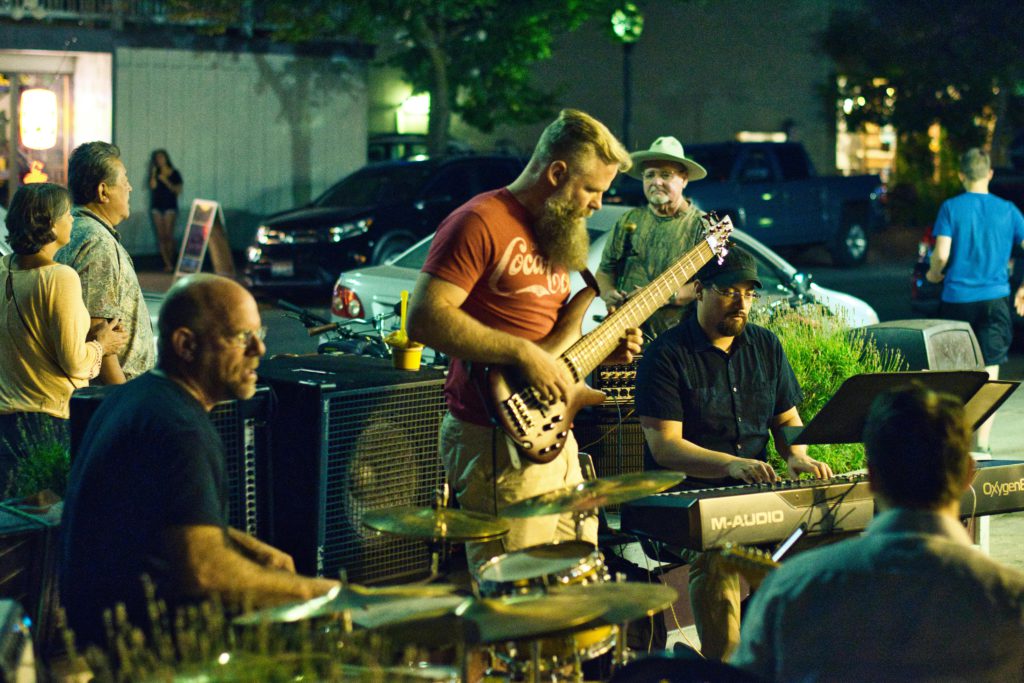 Finding your perfect music venue - a musician's guide. Photo of a band playing outside in the street.
