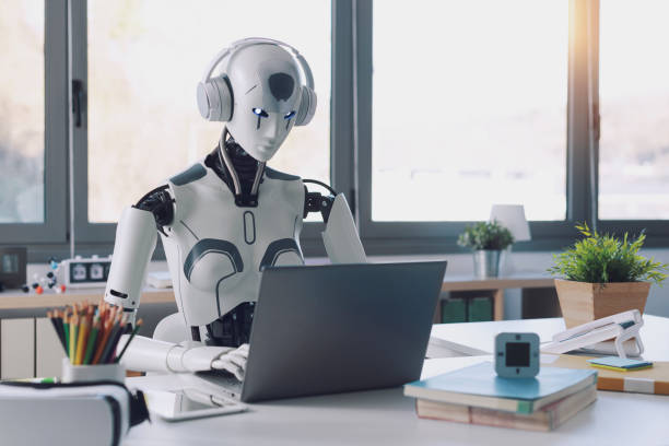 Why fake followers and bots are damaging on Instagram. Photo of a robot in front of a laptop, in an office.
