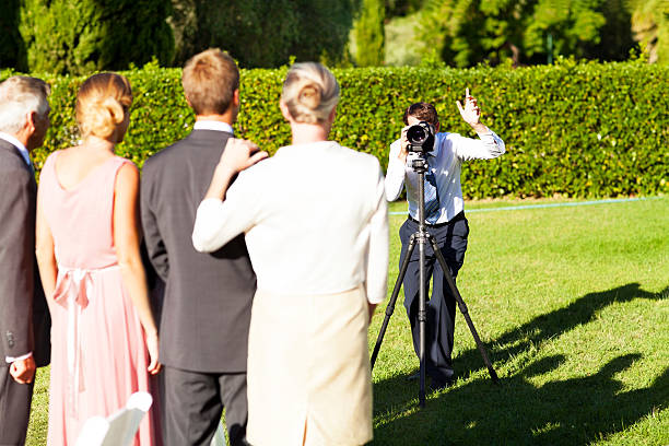 Exploring the art of lifestyle photography - capturing life's authentic moments. Photo of a photographer capturing a group photo at a wedding.