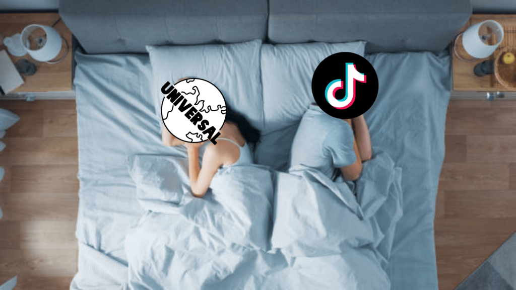 TikTok videos will be unmuted - Universal Music Group end feud. Photo of a man and woman back to back in bed in an argument. Covering their face is a Universal Music Group or TikTok logo.