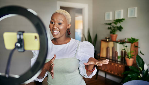 A guide to finding sponsors as an influencer - monetising your online presence. Photo of a woman speaking to her phone, which is being held up by a ring light.