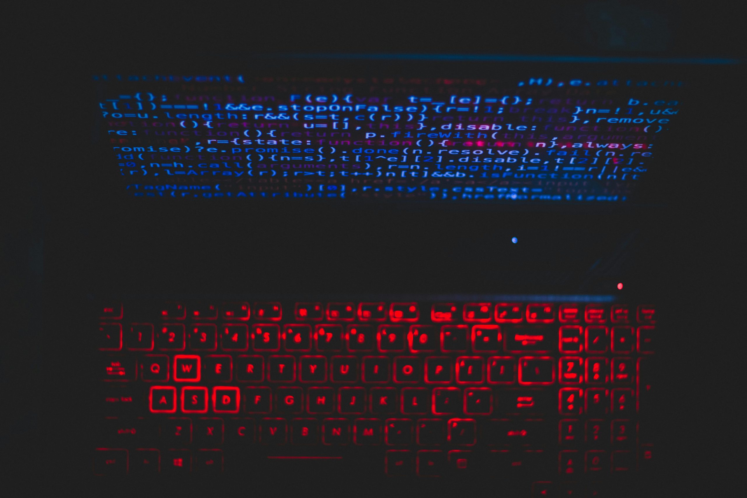 What you need to know about AI on Instagram. Photo of a laptop with red lit up keys and a screen with blue code loaded.