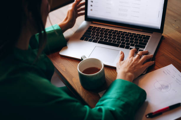 Effective email marketing strategies for musicians. Photo of a person from above on a laptop, sharing their emails. They have a coffee and paper next to them.