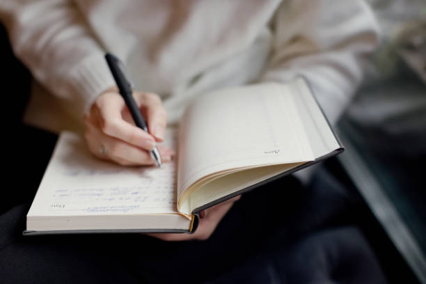 Finding inspiration for writing a book - unlock your creativity. Someone holding a book and a pen.