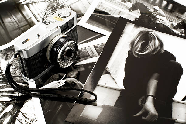 Why you should always update your portfolio. Black and white photo of a 35mm film camera on top of multiple film photos.