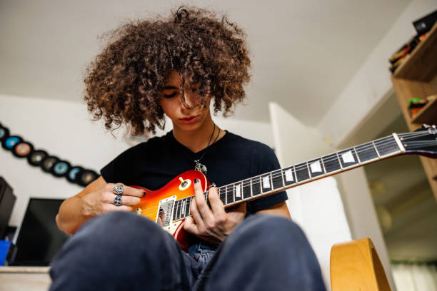 The pressure on young music artists - what you need to know. Photo of a teenager playing guitar.