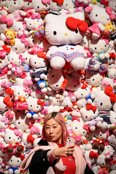 DIY music videos - creating high-quality content on a budget. Photo of a girl recording herself on her phone in front of a huge wall of Hello Kitty toys.