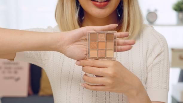 Why small businesses should create video tutorials on how to use their products. Photo of a woman holding up a makeup palette. 