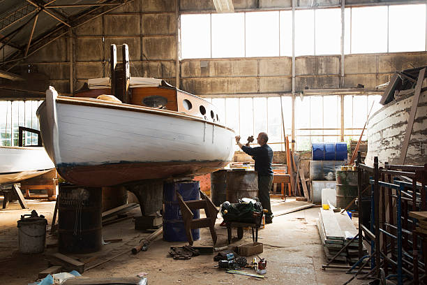 Turning your hobby into a full-time job - pros and cons. Man working on building a boat in a workshop.