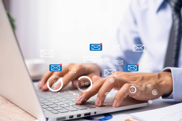 Why you should personalise your emails. Hands on a laptop with lots of email related graphics.