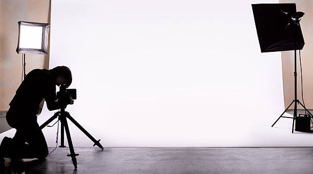 Behind the scenes of a photoshoot - a guide for newcomers. Photo of a photographer kneeling down taking a photo within a studio setting.