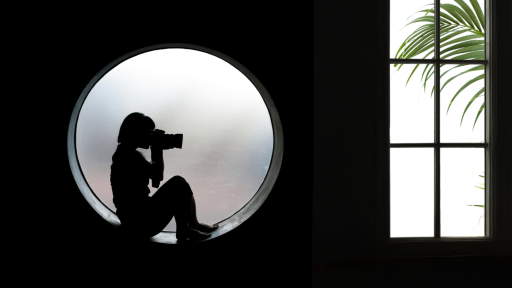 The rule of thirds and other composition techniques - elevating your photography. Photo of a person sat on a circular windowsill with a camera up to their eye. Next to that is a rectangular window.