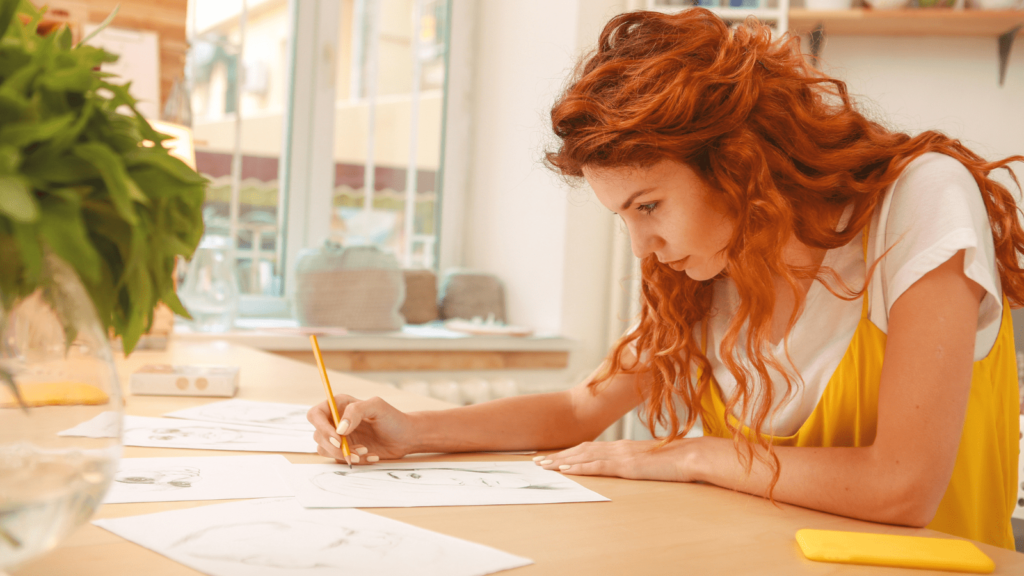 The best fine line equipment for artists. Girl sat at desk drawing.