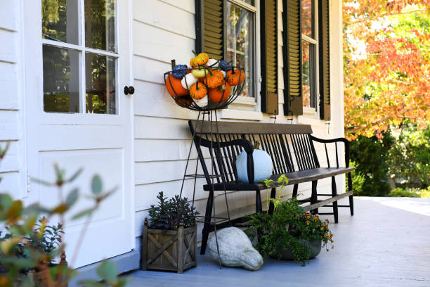 9. Fall Fashion or decor tips. The front of a house with pumpkins and a bench.