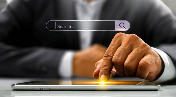 SEO basics - how to get your online business found on Google. Photo of someone in a suit tapping on a tablet lay down in front of them. A search box is on the photo too,