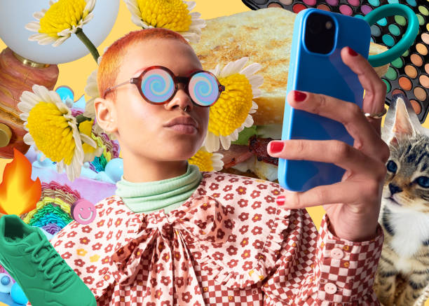 Creative trends of the 2000s. Photo of a person holding a smartphone. The person has round glasses on. Behind them is a background with lots of random items such as; a cat, a trainer, a makeup palette. 