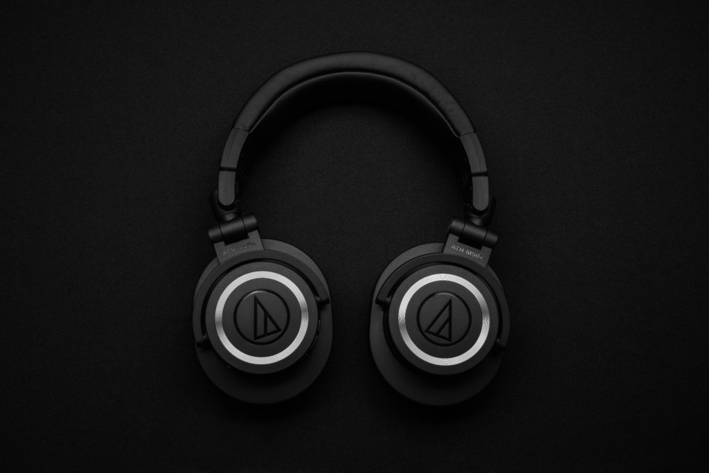 What headphones music lovers should look for in Black Friday sales. Photo of black headphones against a black background.