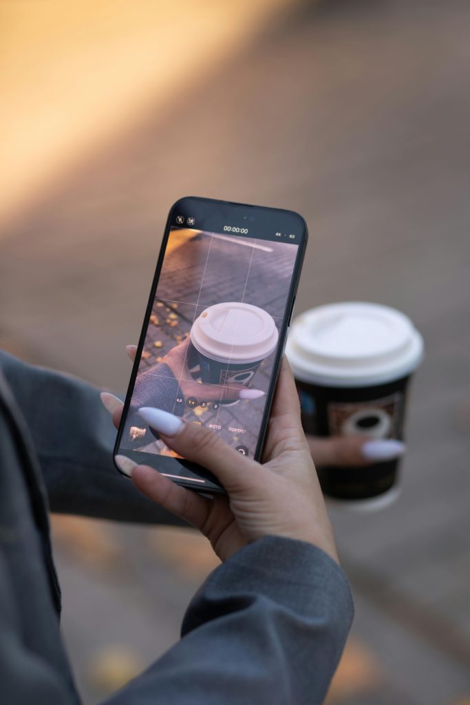 Instagram reduce video quality for clips that aren't popular. Photo of a person taking a photo of their coffee.