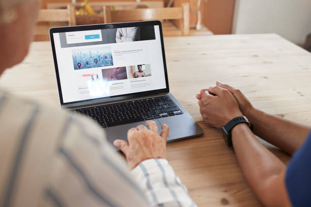 Do I need a website for my small business? Photo of two people sat looking at a website on a laptop.