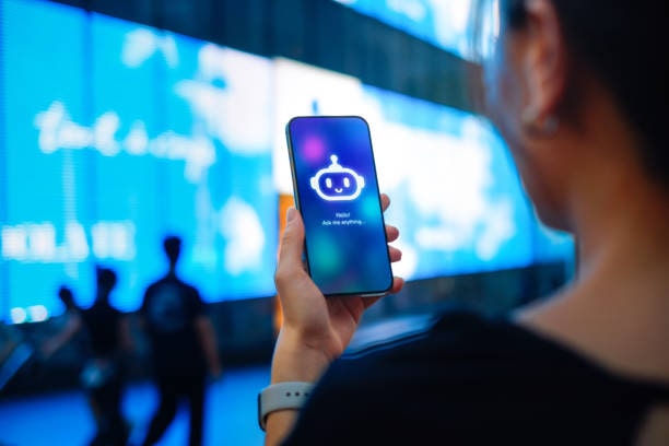 How AI is transforming digital marketing. Photo looking over someone's shoulder while they look at their smartphone with an AI robot on the screen.