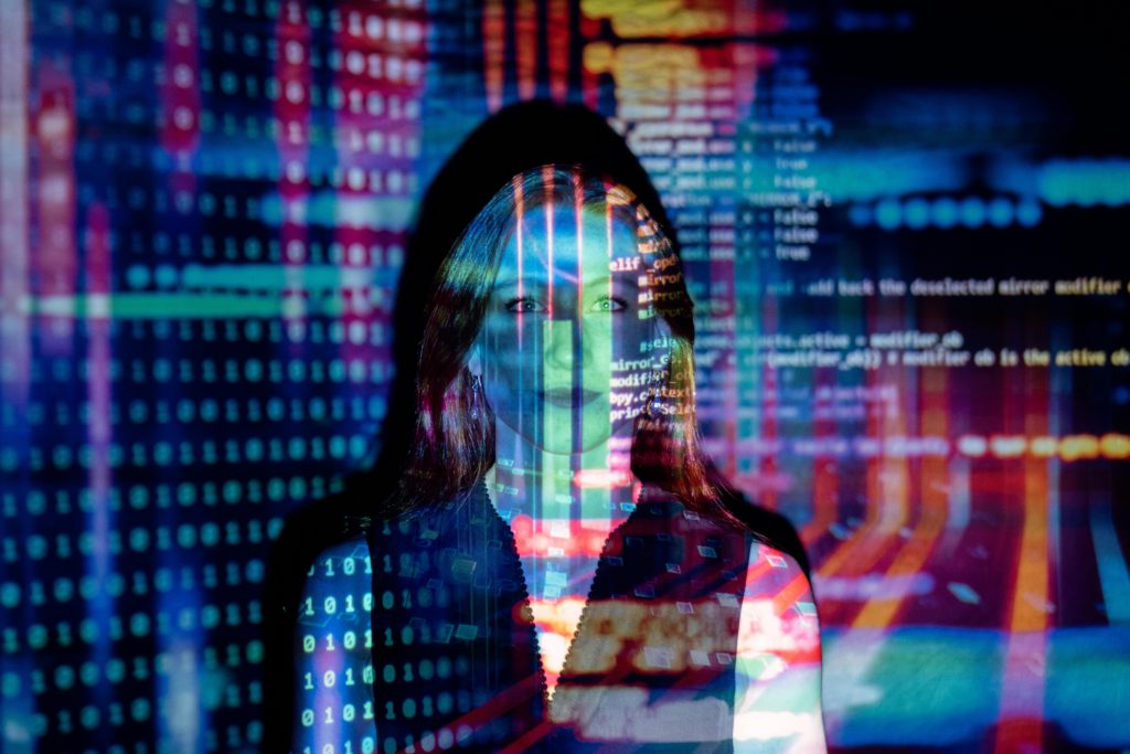 The ethical side of using AI in creative work. Photo of a girl against lots of coding.