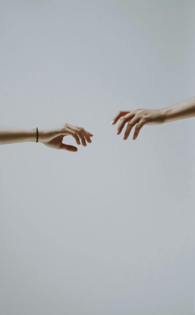 Why my posts aren’t reaching my audience and how to improve reach. Photo of two arms reaching out to each other.