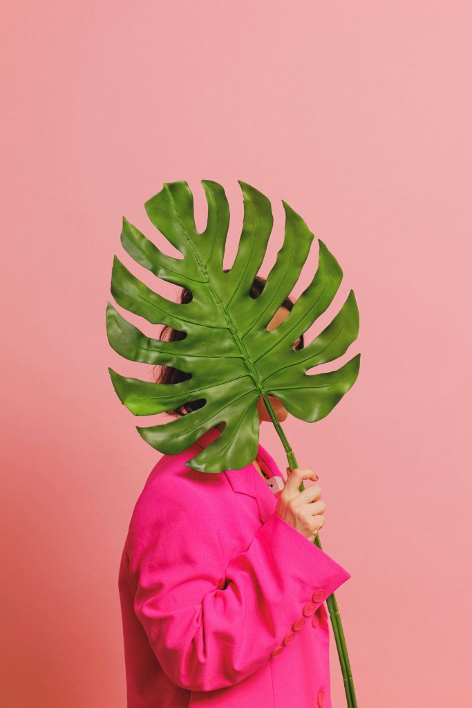 How to hide/remove a post you're tagged in on Instagram. Photo of a person stood behind a giant leaf.