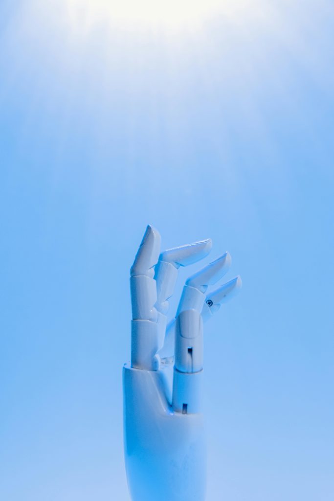The ethical use of AI in social media content creation. Photo of a blue robotic hand.