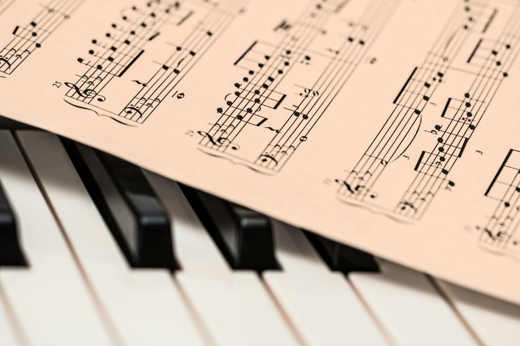 How to build sight-reading skills from scratch. Photo of musical notes on a sheet by a keyboard.