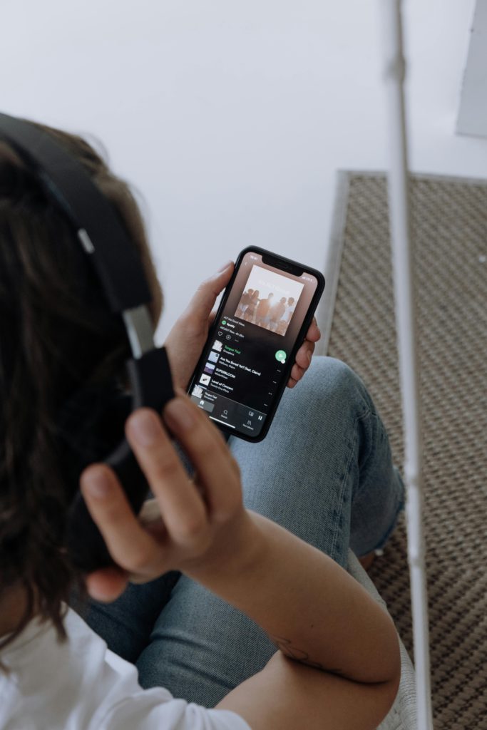 How to create a cohesive playlist that showcases your music. Photo of someone streaming music.