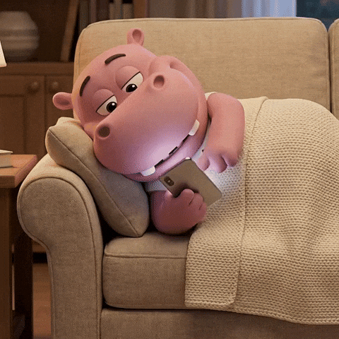 Everything you need to know about updating your Instagram username. GIF of a hippo scrolling their phone lay on the sofa.